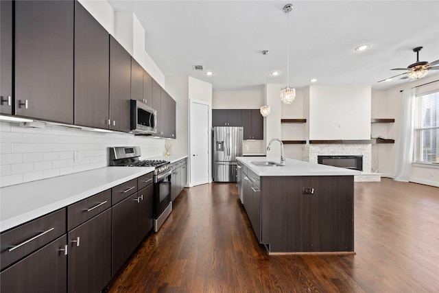 kitchen featuring dark wood finished floors, appliances with stainless steel finishes, light countertops, and a sink