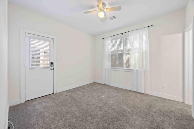 spare room with baseboards, carpet, visible vents, and ceiling fan