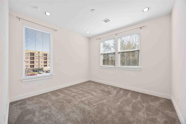 carpeted spare room featuring recessed lighting, baseboards, and visible vents