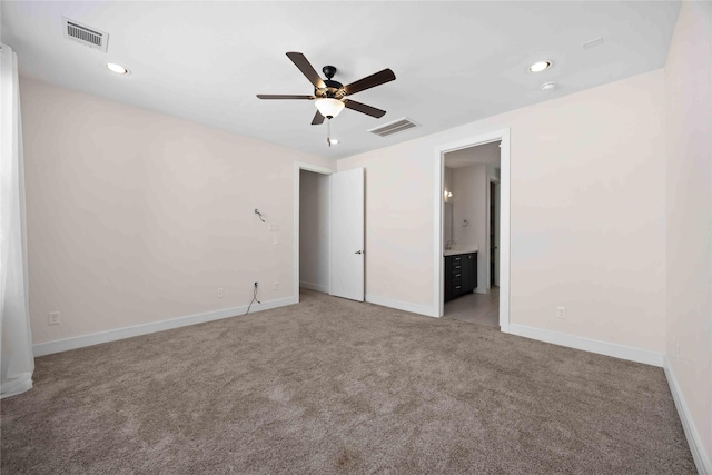 unfurnished bedroom with light carpet, visible vents, ensuite bathroom, and baseboards