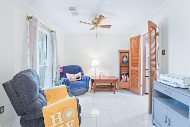 sitting room with visible vents, crown molding, and ceiling fan