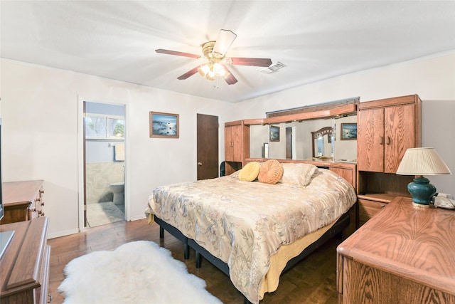 bedroom featuring light wood finished floors, visible vents, baseboards, ensuite bath, and a ceiling fan