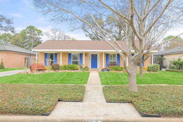 view of front facade with brick siding, a porch, a front lawn, and fence