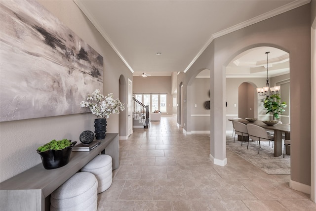 hallway featuring baseboards, arched walkways, and ornamental molding