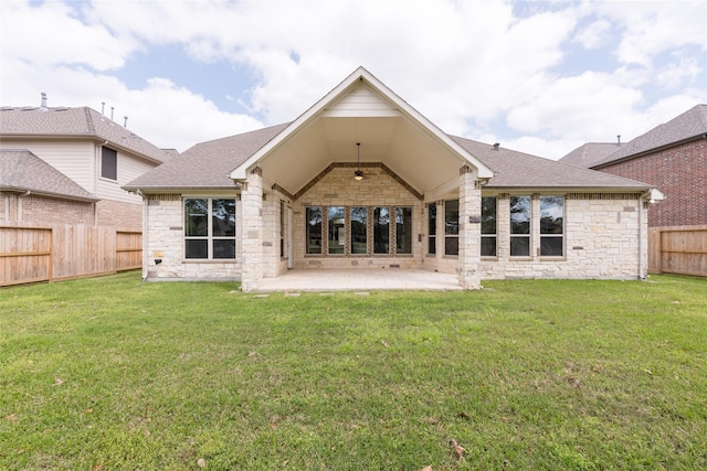 back of house with a patio, a yard, a fenced backyard, and stone siding