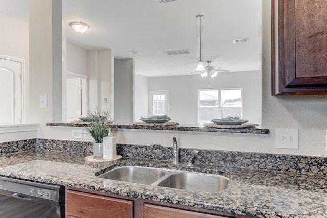 kitchen featuring visible vents, a ceiling fan, a sink, dark stone countertops, and dishwasher