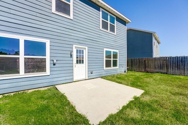 rear view of property with a patio area, a lawn, and fence