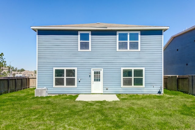 rear view of house with a yard and a fenced backyard