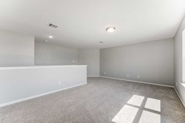 empty room featuring visible vents, baseboards, and carpet floors