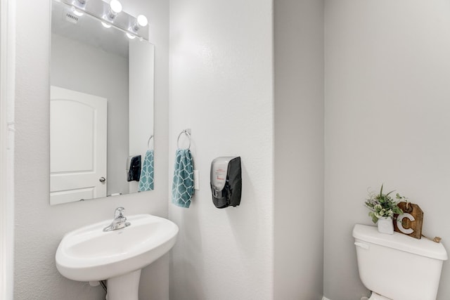 bathroom featuring a sink, visible vents, and toilet