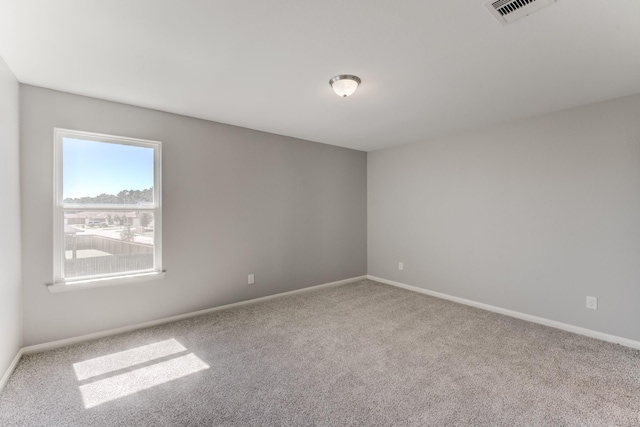 carpeted spare room with baseboards and visible vents