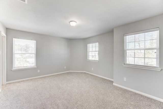 carpeted spare room featuring baseboards