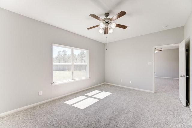 unfurnished room featuring baseboards, light carpet, and a ceiling fan