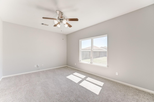 carpeted spare room with a ceiling fan, baseboards, and visible vents