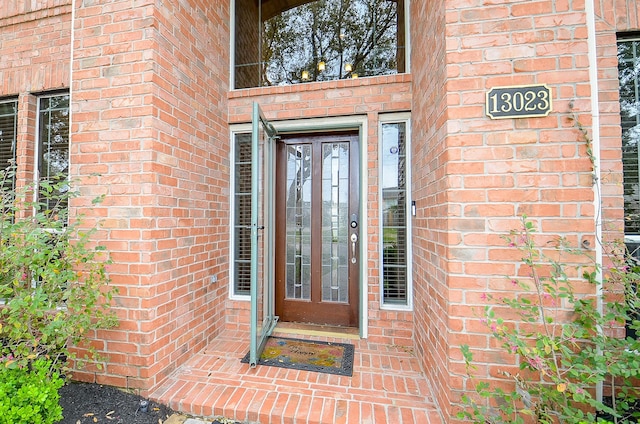 property entrance featuring brick siding