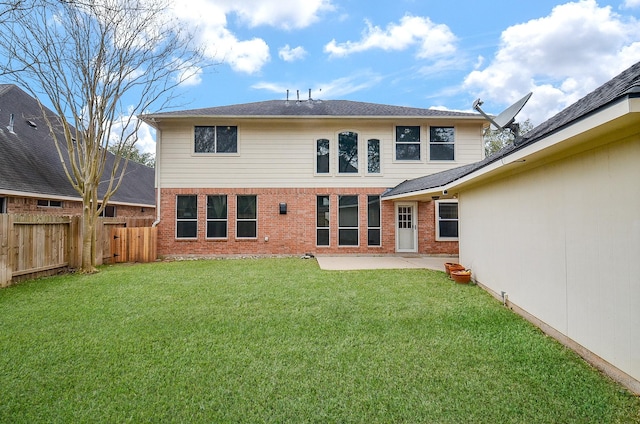 rear view of property with a yard, a patio area, brick siding, and a fenced backyard