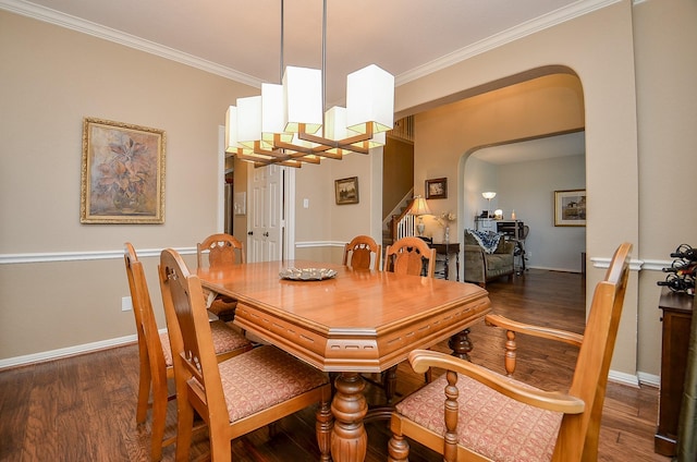 dining area featuring arched walkways, a notable chandelier, crown molding, and wood finished floors