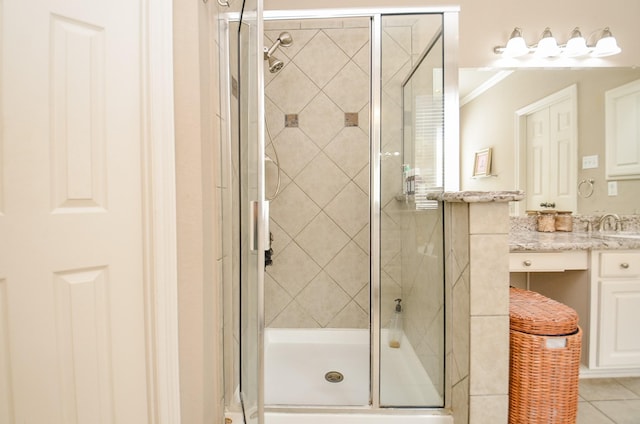 bathroom with tile patterned floors, a stall shower, vanity, and ornamental molding