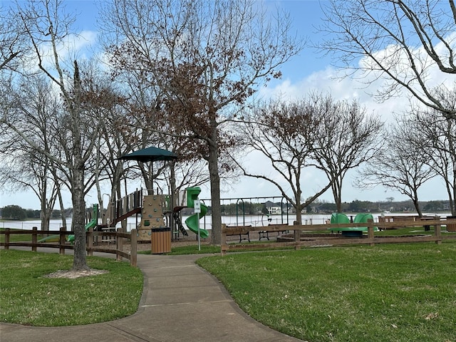 view of property's community featuring a lawn, playground community, and a water view