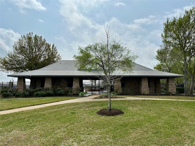 view of front of property with metal roof and a front lawn