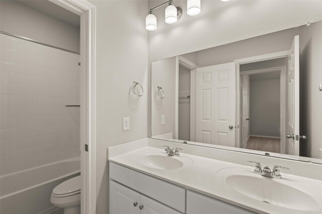 full bathroom featuring double vanity, toilet, shower / washtub combination, and a sink