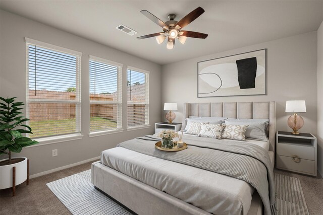 bedroom with baseboards, visible vents, carpet floors, and ceiling fan