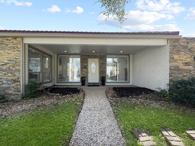 entrance to property featuring brick siding