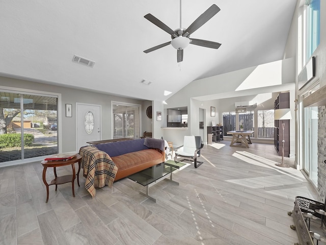 bedroom with visible vents, multiple windows, high vaulted ceiling, and wood finished floors