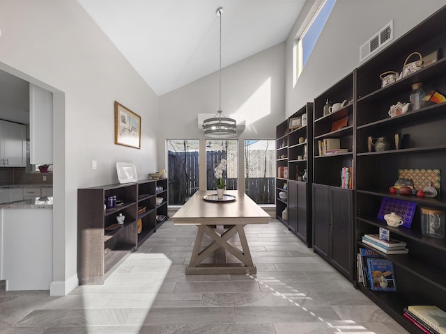 dining room with visible vents and high vaulted ceiling