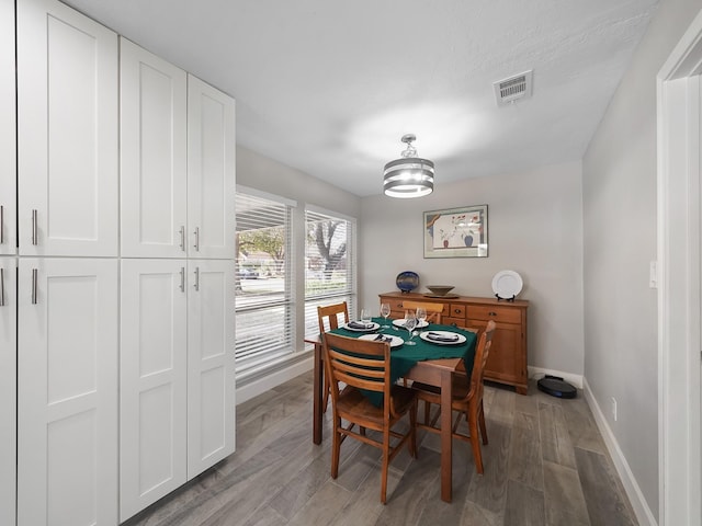 dining room featuring visible vents, light wood-type flooring, and baseboards