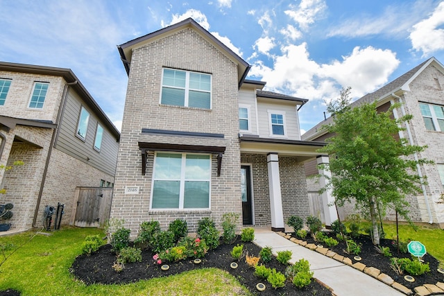 view of front facade with brick siding and a front yard