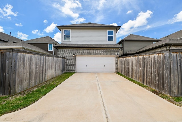 exterior space featuring brick siding, an attached garage, concrete driveway, and fence