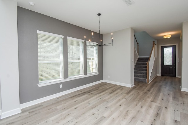 unfurnished dining area with a wealth of natural light, visible vents, stairway, light wood-style floors, and baseboards