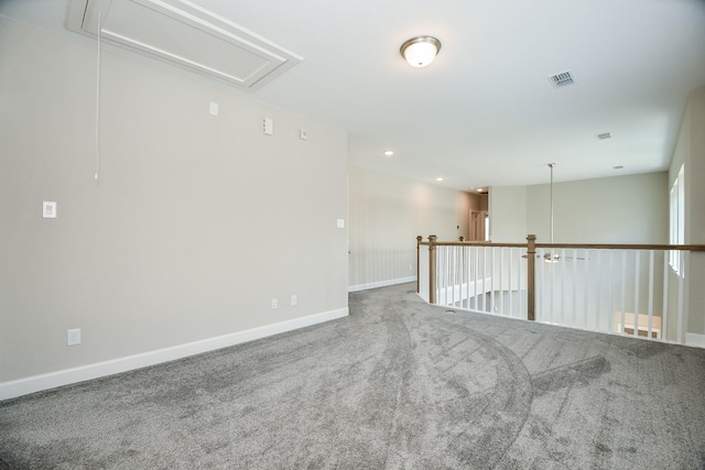 unfurnished room with visible vents, recessed lighting, carpet flooring, baseboards, and attic access