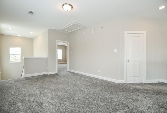 carpeted empty room featuring recessed lighting, visible vents, baseboards, and attic access