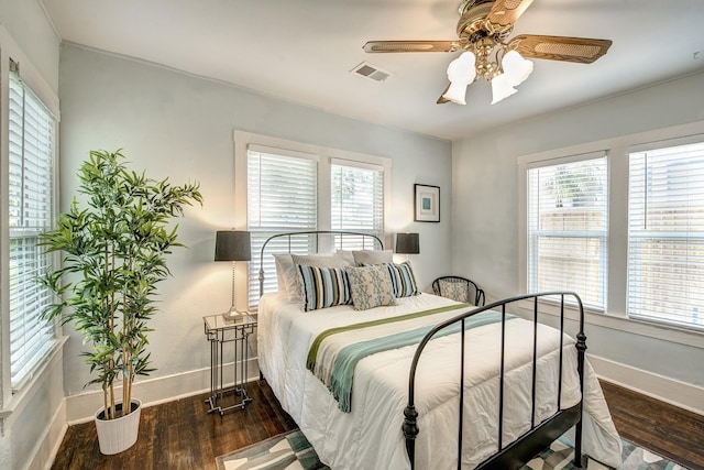 bedroom with visible vents, ceiling fan, baseboards, and wood finished floors