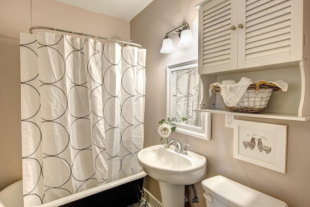 full bathroom with toilet, shower / bathtub combination with curtain, and a sink