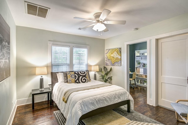 bedroom featuring visible vents, baseboards, wood finished floors, and a ceiling fan