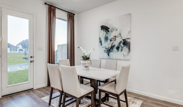 dining space with wood finished floors and baseboards