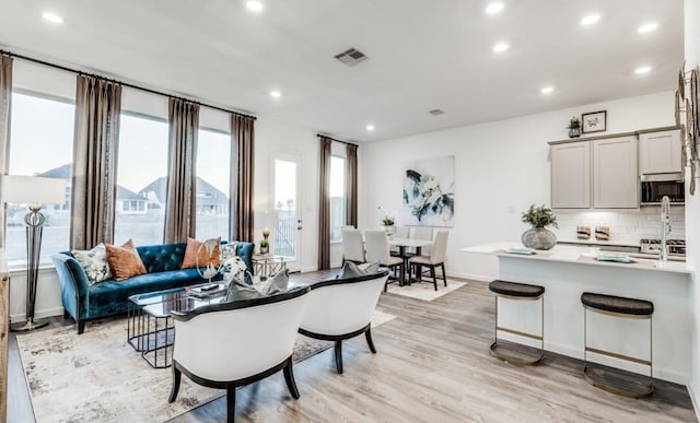 living room with visible vents, recessed lighting, and light wood-style floors