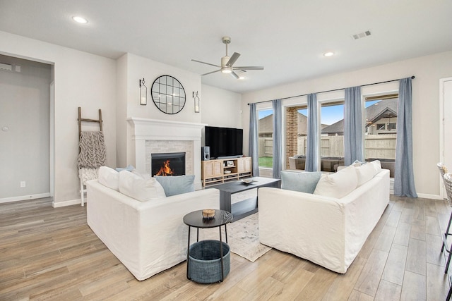 living area with baseboards, visible vents, recessed lighting, a fireplace, and light wood-type flooring