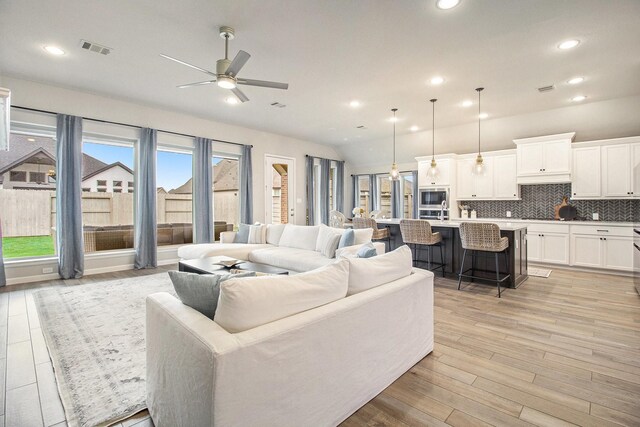 living area featuring recessed lighting, visible vents, light wood-style floors, and ceiling fan