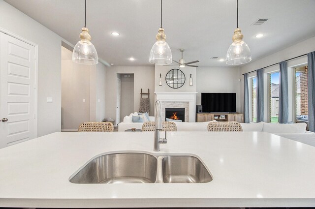 kitchen featuring hanging light fixtures, open floor plan, and a sink