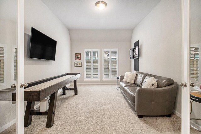 living area with baseboards and light carpet