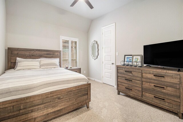 bedroom with baseboards, light colored carpet, lofted ceiling, and a ceiling fan