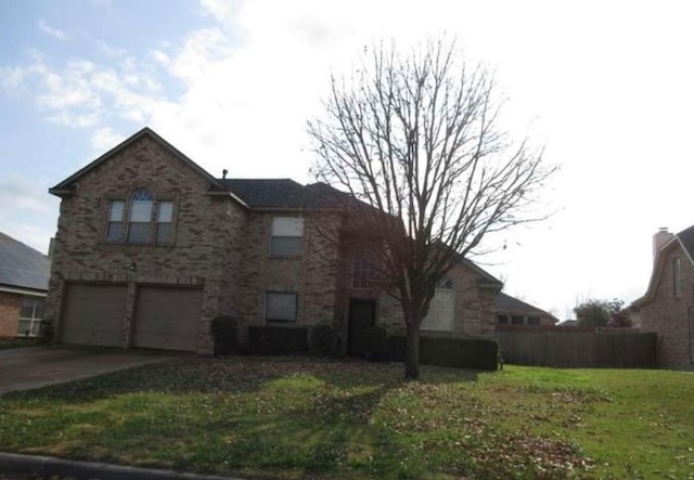 exterior space featuring an attached garage, concrete driveway, a front lawn, and fence