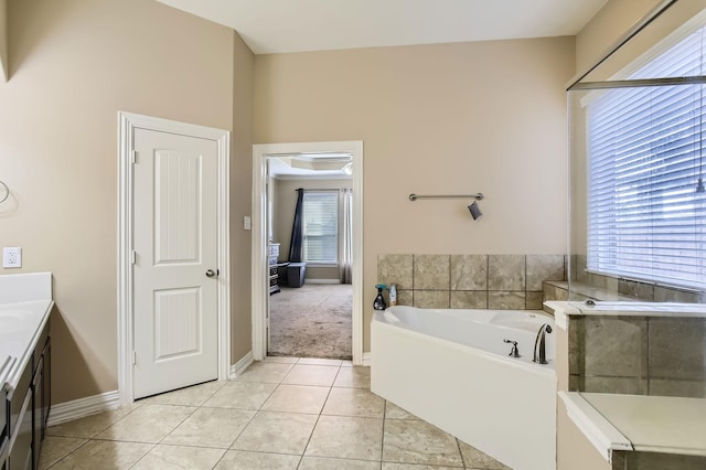 bathroom featuring tile patterned floors, baseboards, vanity, and a garden tub