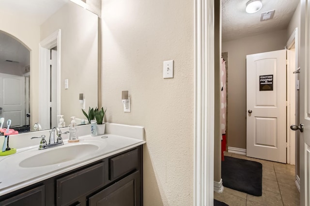 full bathroom featuring visible vents, a textured ceiling, vanity, and tile patterned flooring