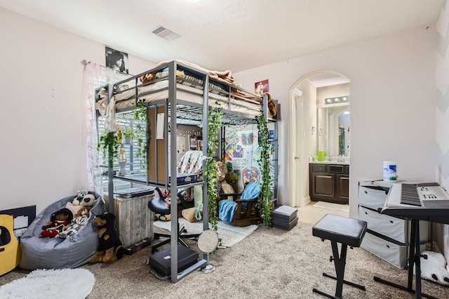 workout room featuring arched walkways, visible vents, and carpet