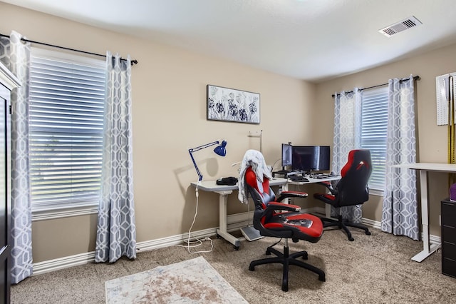 carpeted office featuring visible vents and baseboards